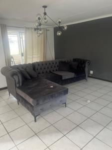 ein Wohnzimmer mit einem Sofa und einem Tisch in der Unterkunft 8 on twentieth in Brakpan