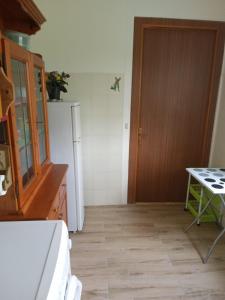 eine Küche mit einem Kühlschrank, einem Tisch und einer Tür in der Unterkunft Casa Dirindo in Carrodano Inferiore