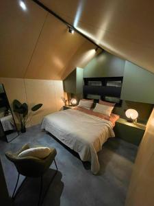 a bedroom with a large bed and a chair at Diamond Suite in the woods in Holten