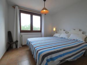 a bedroom with a bed with a blue and white striped blanket at Dalí in Begur +11 photos