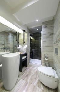y baño grande con bañera y aseo. en The Place Suites by Cey, en Estambul