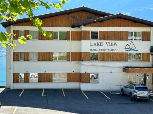 因特拉肯的住宿－Hotel Lakeview bei Interlaken，停车场内有停车位的建筑物