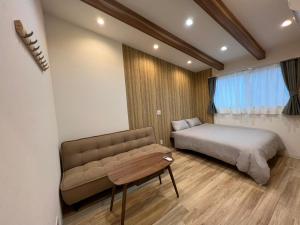 um quarto com uma cama, um sofá e uma mesa em 蝉時雨－大正 em Osaka