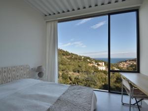 - une chambre avec un lit et une grande fenêtre dans l'établissement Energías Serenas, à Begur