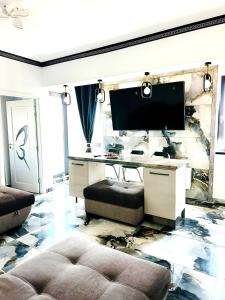 un soggiorno con TV e scrivania di Jolie Studios & Apartments a Eforie Nord