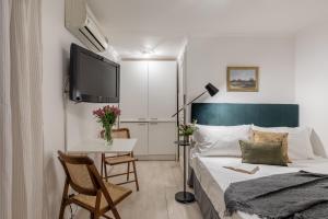 a bedroom with a bed and a table and a tv at Basic Studio - 350 m far from Fontana di Trevi in Rome