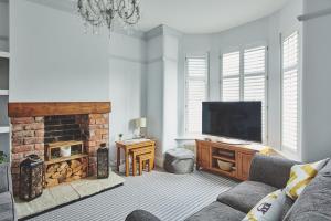 a living room with a fireplace and a television at Hollie Cottage in Lytham St Annes