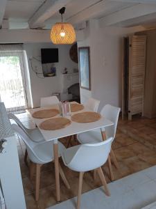 comedor con mesa blanca y sillas en Afiartis Almira Cottage en Kárpatos