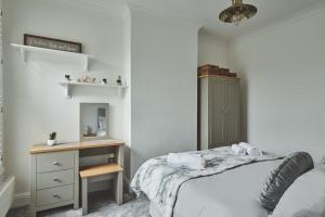 a bedroom with a bed and a dresser and a mirror at Hollie Cottage in Lytham St Annes