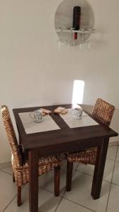 uma mesa de madeira com 2 cadeiras e um lustre em Casa Alessandro em Villasimius