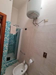 y baño con lavabo, aseo y ducha. en Casa Alessandro en Villasimius