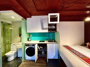 a bathroom with a washing machine in the middle of a room at Maison Mackeno in Hanoi
