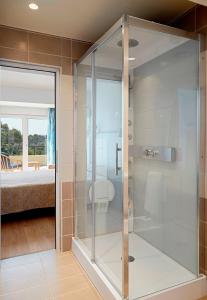 a glass shower in a room with a bedroom at Helion Apartments in Gouvia