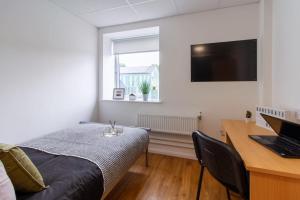 a bedroom with a bed and a desk with a laptop at For Students Only Ensuite Bedrooms at Danesgate House in Lincoln in Lincoln