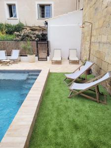a backyard with a swimming pool and two lounge chairs at Maison 1634 - Centre historique, parking, petit-dejeuner compris, climatisation, piscine in Pézenas