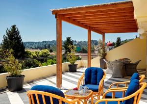 een patio met stoelen, een tafel en een pergola bij Helion Apartments in Gouvia