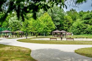 a path in a park with benches and gazebos at Dom z Ogrodem w Spale in Spała