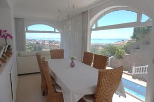 comedor con mesa blanca y sillas en Villa Seaview Suncoast Luxury, en Málaga