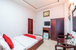 a hotel room with a bed and a television at OYO 265 An Thinh Loc in Danang