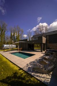 una piscina con tumbonas y una casa en Le Fermage - logement avec piscine, sauna et jacuzzi, 
