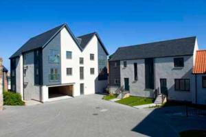 a white house with a black roof in a driveway at 18 Mill Wharf Apartment in Berwick-Upon-Tweed