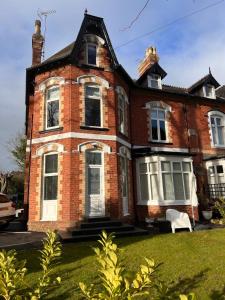 an old brick house with a lawn in front of it at Green Corner Villa - Cosy Luxury in Central Torquay with Free Parking & EV in Torquay