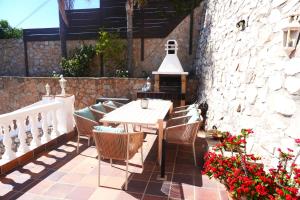 a patio with a wooden table and chairs and flowers at Villa Seaview Suncoast Luxury in Málaga