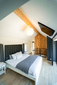 1 dormitorio con 1 cama grande en el ático en Le Fermage - logement avec piscine, sauna et jacuzzi, 