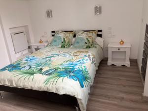 a bedroom with a bed with a blue and white comforter at 2 pièces rez-de-jardin dans maison avec piscine in Villeneuve-Loubet