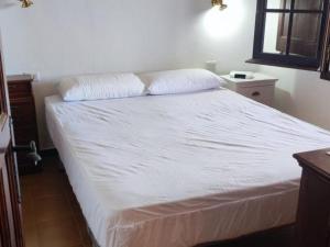 a bedroom with a bed with white sheets and a window at Josep in Begur