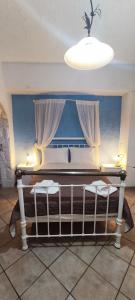 een kamer met een bed met gordijnen en een licht bij Keramos in Zarós
