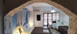 1 dormitorio con 1 cama y 1 habitación con sofá en Keramos, en Zarós