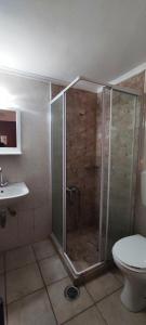a bathroom with a shower with a toilet and a sink at Keramos in Zarós