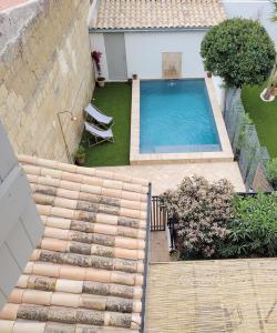 uma vista sobre um quintal com uma piscina em Maison 1634 - Centre historique, parking, petit-dejeuner compris, climatisation, piscine em Pézenas