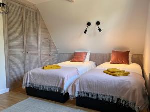 - 2 lits installés l'un à côté de l'autre dans une chambre dans l'établissement Smolniki Leśna Oaza, à Smolniki