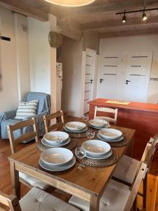 ein Holztisch mit Tellern und Weingläsern darauf in der Unterkunft Smolniki Leśna Oaza in Smolniki