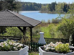 ein Garten mit einem Pavillon und einigen Blumen in der Unterkunft Smolniki Leśna Oaza in Smolniki