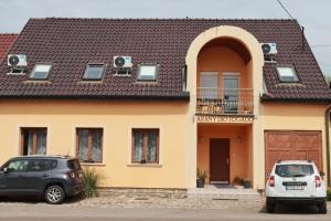 two cars parked in front of a house at Arany Dió Fogadó in Eger