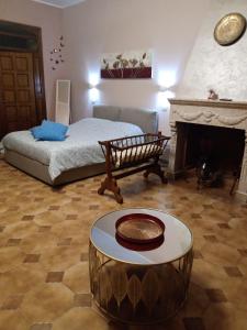 1 dormitorio con cama y mesa frente a una chimenea en Ca' di Renzo en Macchiagodena