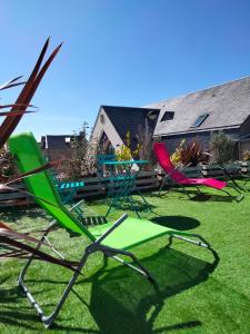 un gruppo di sedie da giardino sedute sull'erba di Le Petit Dernier a Portbail