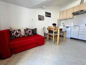 ein Wohnzimmer mit einem roten Sofa und einem Tisch in der Unterkunft Old Town Rab Pjaceta Accommodation in Rab