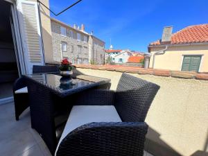 eine Terrasse mit einem Tisch und Stühlen auf dem Balkon in der Unterkunft Old Town Rab Pjaceta Accommodation in Rab