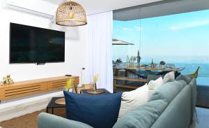 uma sala de estar com um sofá e uma grande janela em Villa-SELAVI 3 unit complex with infinity pool em Tiberias