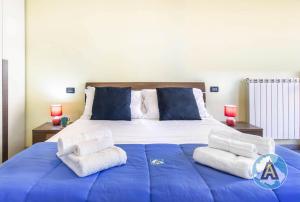 uma grande cama azul com toalhas por cima em Luminoso a due passi dal mare 51a em Montesilvano