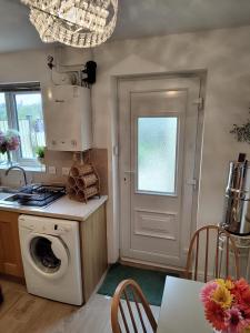a kitchen with a washing machine next to a door at Mallard Court contractor/holiday home in Stamford in Stamford