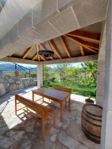 a patio with a table and benches and a barrel at Apartman Dorotea in Trebinje