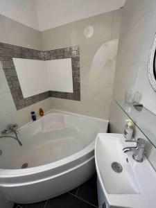 Baño blanco con bañera y lavamanos en Appartement atypique et original, en Niza