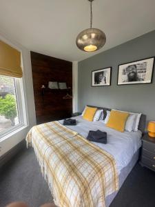 a bedroom with a large bed with a plaid blanket at Green Corner Villa in Torquay