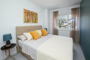 um quarto com uma grande cama branca com almofadas amarelas em Villa Unica em Biograd na Moru