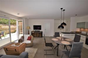 a living room with a table and a kitchen at Compass-App-5 in Hohwacht